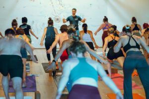 a man teaches a yoga class to a group of people
