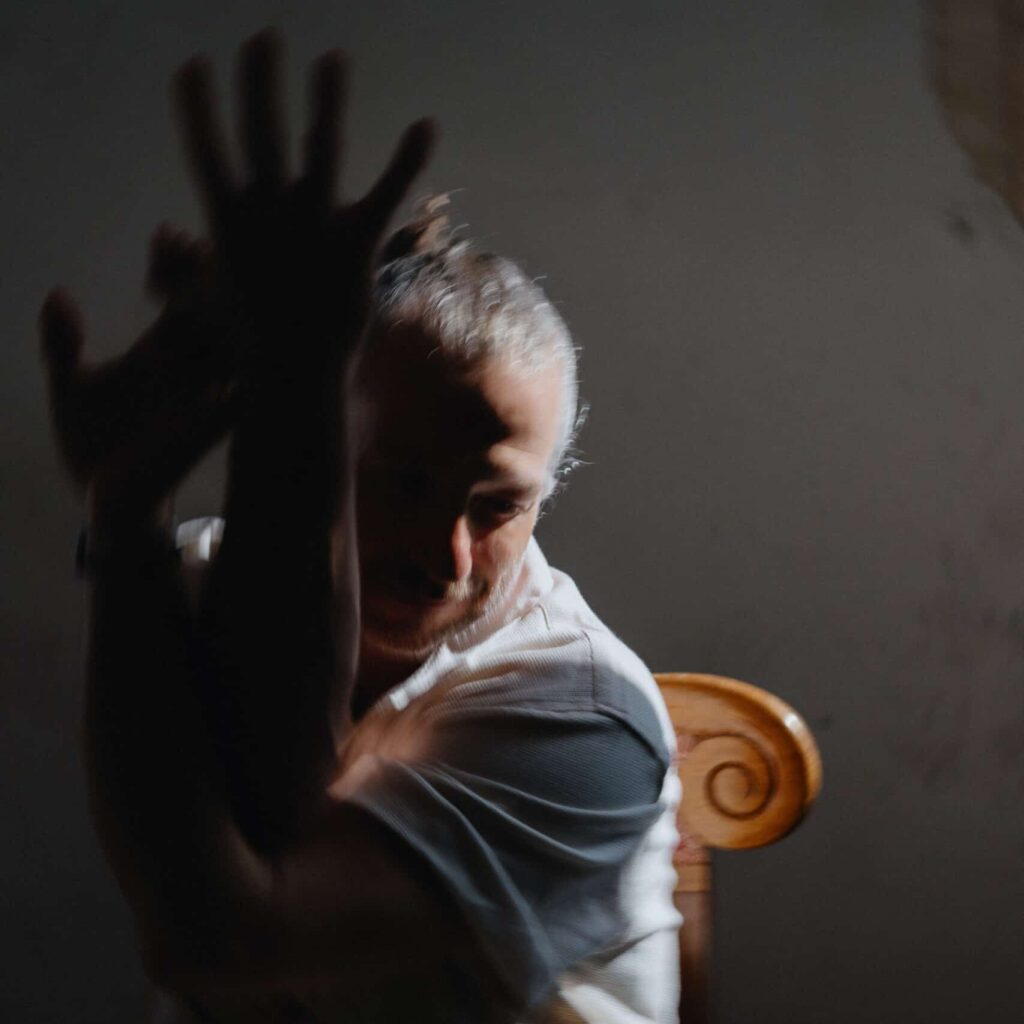 a man poses with his arms twisted together