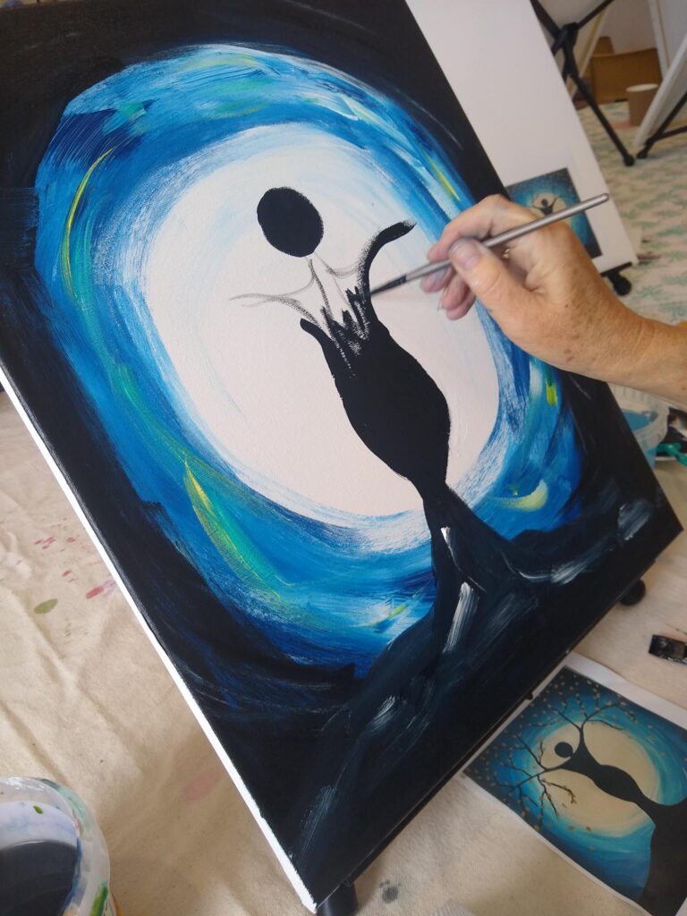 A hand paints a figure surrounded by blue and black swirls